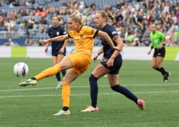 May 11, 2025; Seattle, Washington, USA; Seattle Reign midfielder Ainsley McCammon (16) comes up on Houston Dash defender Natalie Jacobs (4) as she kicks the ball back down the field in the second half of the game at Lumen Field. Mandatory Credit: Melissa Levin-Imagn Images